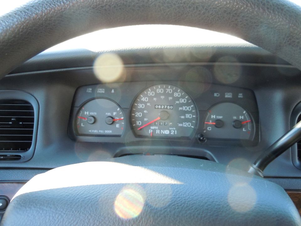 Close-up of a car's dashboard with gauges and steering wheel.