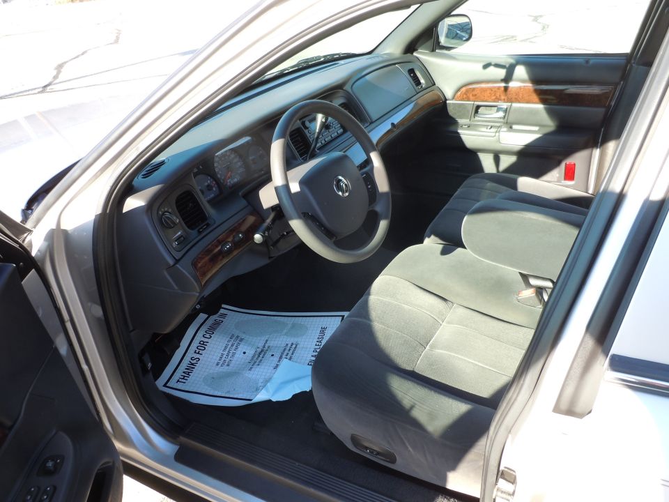 Interior of a 2001 Ford Crown Victoria showing dashboard, steering wheel, and front seat.