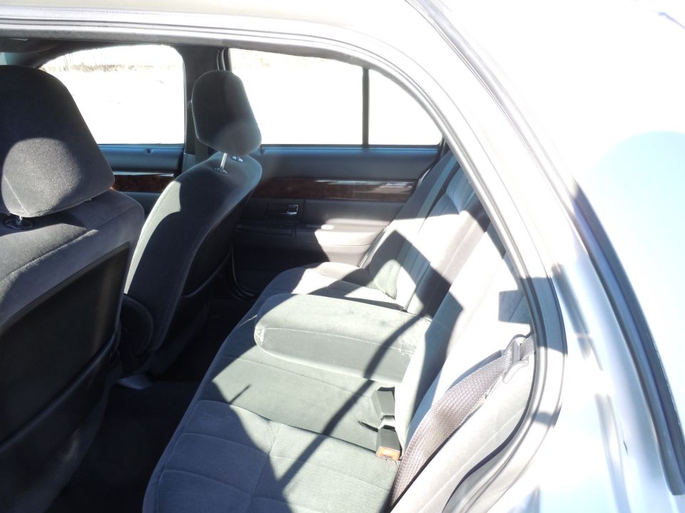 Interior rear seat of a sedan with gray cloth upholstery.