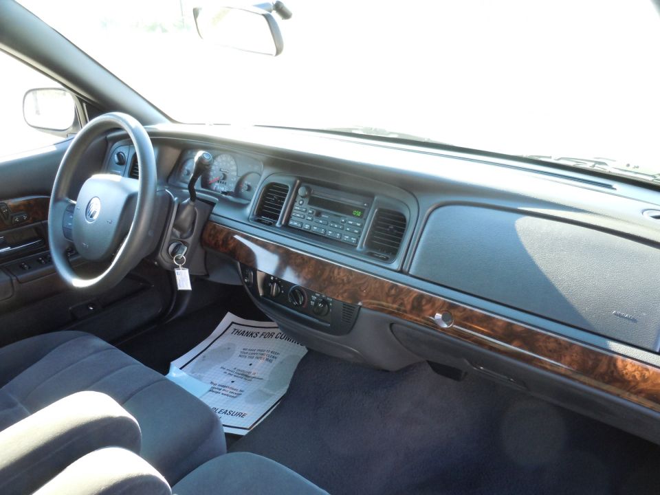 Interior of a 2001 Ford Crown Victoria, showing dashboard, steering wheel, and seats.