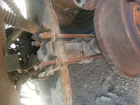 1995 Ford Bronco - This is a close-up, low-angle shot of the heavily rusted suspension and drum brake assembly of a vehicle, likely a truck or SUV. The image…