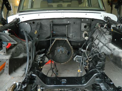 1979 Ford Bronco - The engine bay of a classic Ford Bronco is shown with the engine removed, revealing the firewall, frame, and transmission housing. Various…