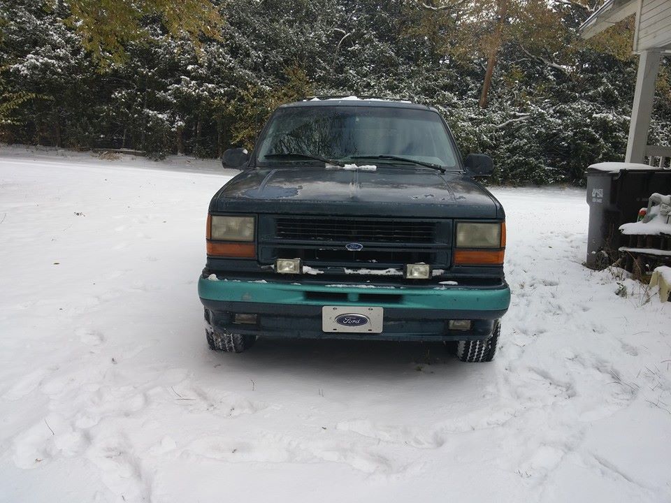 Photo of the front of a green Ford SUV parked in the snow