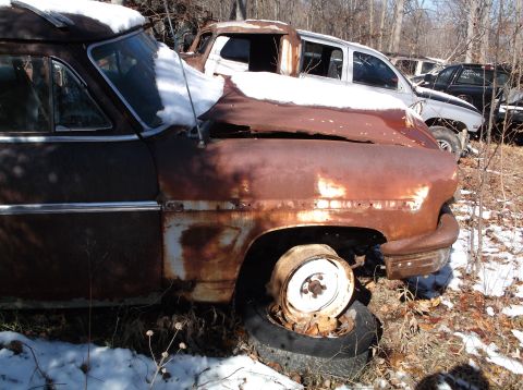 1974 Dodge Challenger - A weathered vehicle sits in a yard, with another car partially visible behind it.