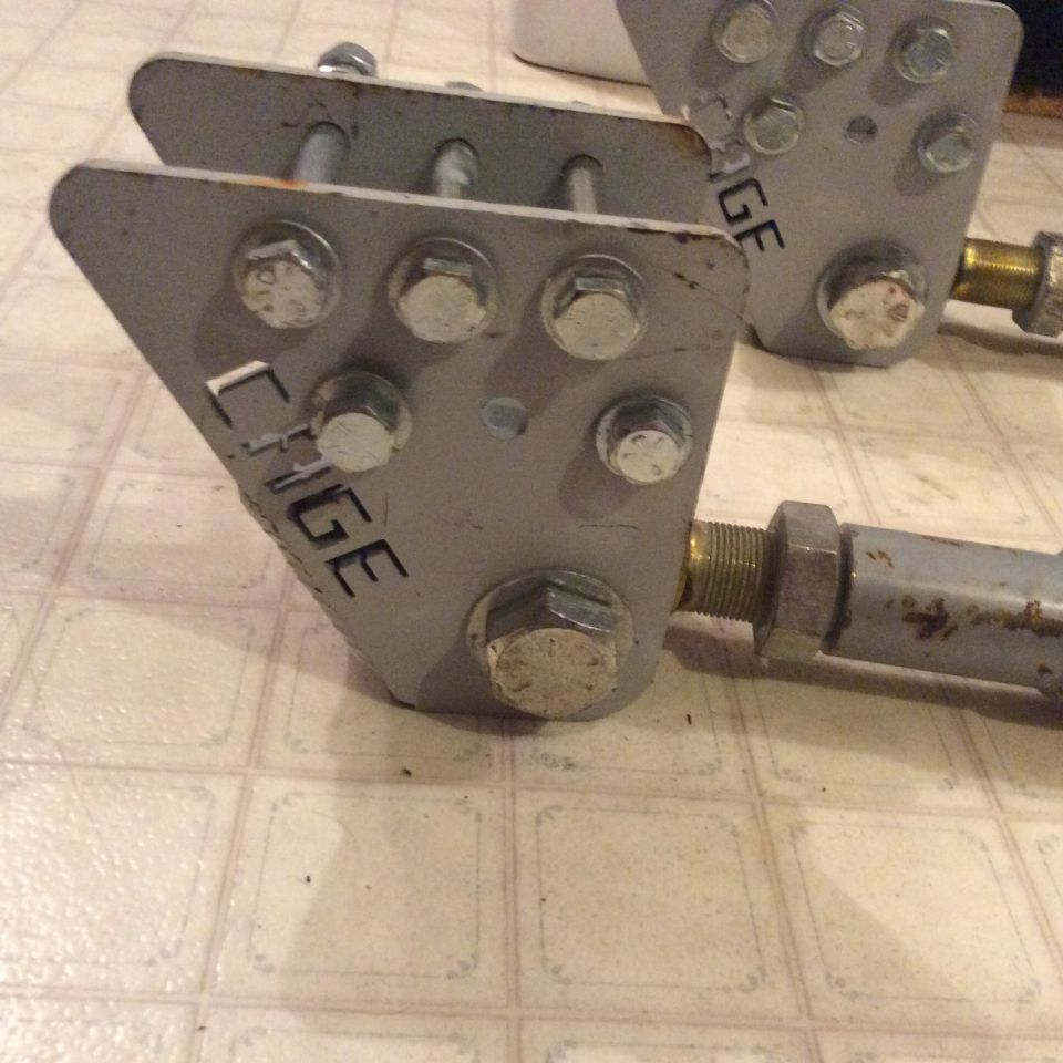 Custom gray metal suspension components with "CAGE" text, attached to rods.