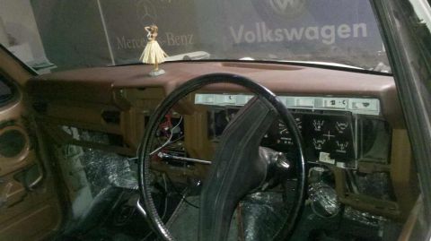 1982 Ford Bronco - The interior of a vehicle is shown, focusing on the dashboard and steering wheel. The dashboard appears to be brown and is partially disass…
