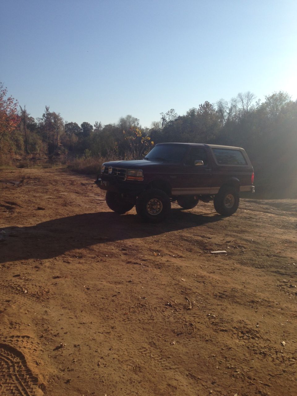 1996 Ford Bronco parked on a dirt lot.