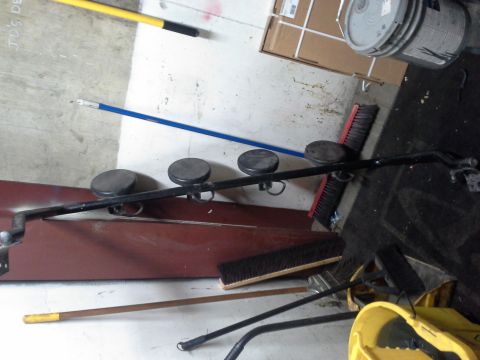 1991 Ford F-250 - This image shows a collection of cleaning supplies, including brooms, a mop bucket, and a paint can, arranged on a concrete floor.