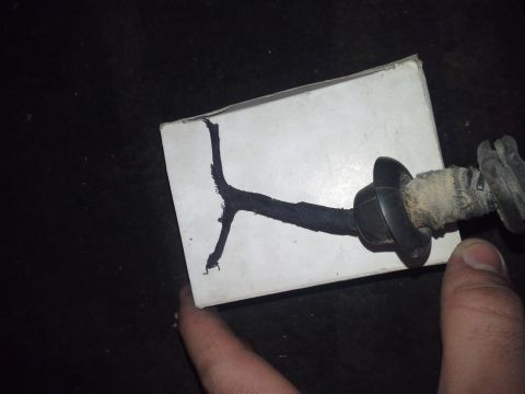 1991 Ford F-250 - A black wire harness with a rubber grommet and fabric wrap is shown resting on a white surface. A person's thumb is visible in the lower ri…
