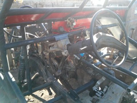 1986 Ford Bronco - Interior view of a custom-built vehicle, likely a dune buggy or off-road buggy, showing a steering wheel, dashboard wiring, and a roll cage…