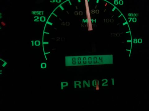 1995 Ford Bronco - A close-up shot of a car's dashboard at night shows a speedometer with a needle pointing to approximately 70 MPH and a digital odometer dis…