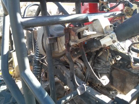 1986 Ford Bronco - This is a close-up view of the steering column and wiring harness of a vehicle, likely a 1986 Ford Bronco, with a focus on the mechanical c…