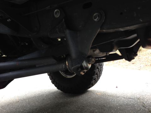 1993 Ford Bronco - A low-angle view of the undercarriage of a 1993 Ford Bronco, focusing on the suspension and steering components, including the tie rod and…