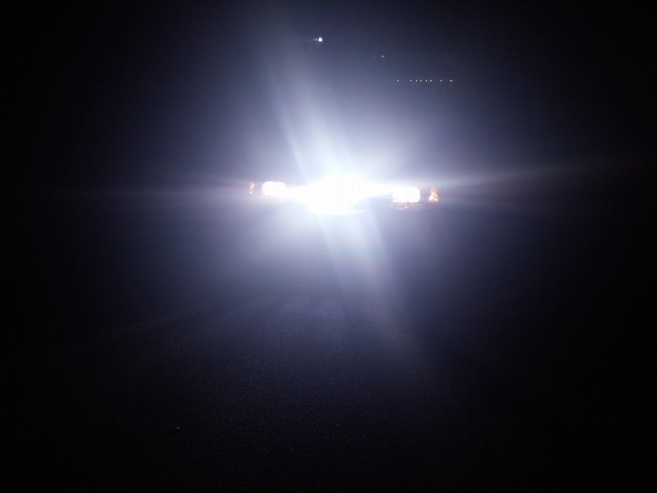 Night photo of oncoming vehicle headlights glaring in the dark