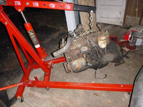 1953 Plymouth Belvedere - Engine hoist lifting a V8 engine out of a vehicle.