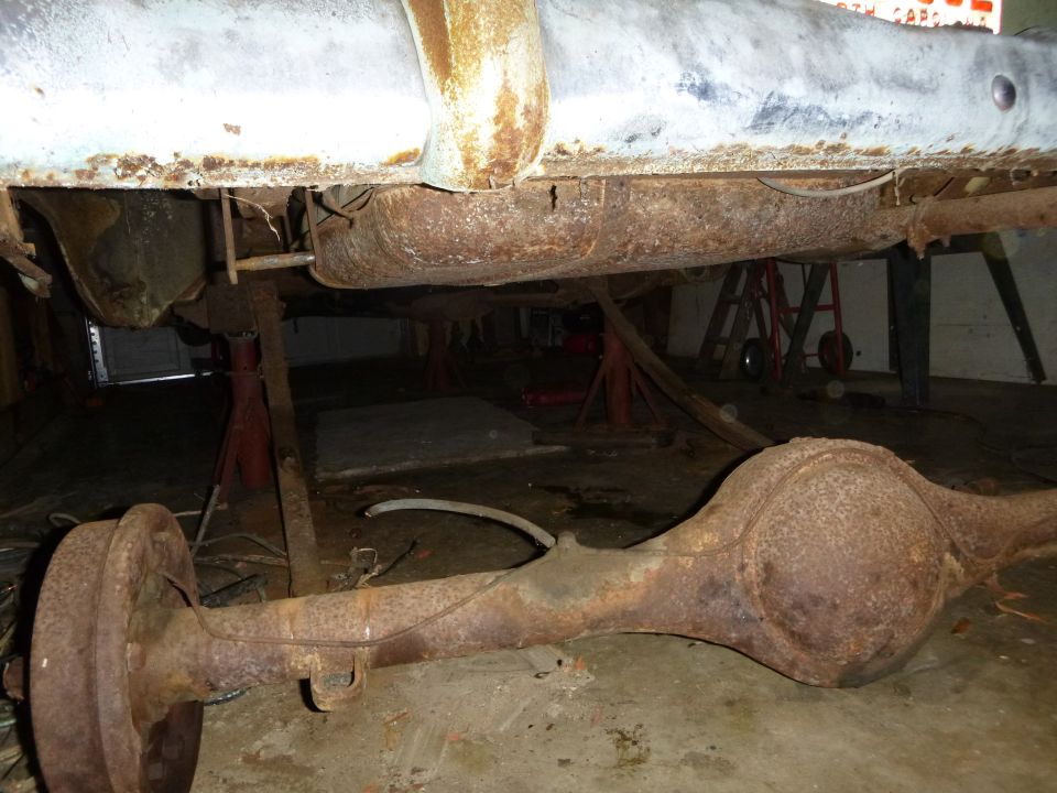 Rusty rear axle and undercarriage of a vehicle on jack stands