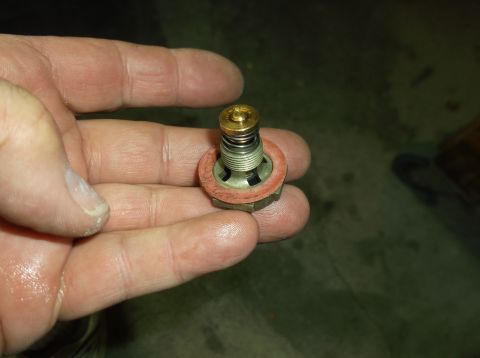 1979 Ford Ranchero - A close-up shows a thermostat valve with a red gasket and spring mechanism.