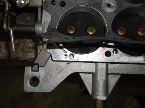 1979 Ford Ranchero - A close-up view of a carburetor component, showing internal mechanisms and a gasket.