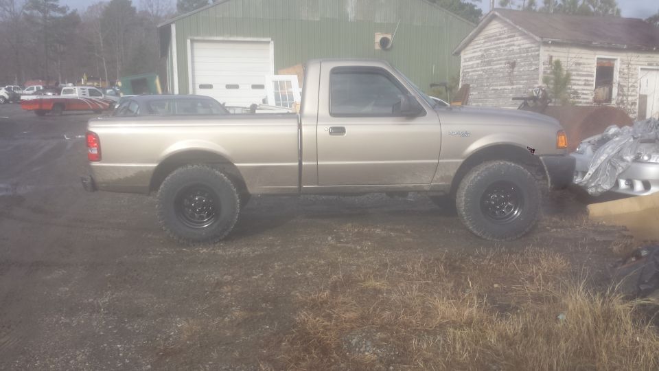 Gold pickup truck with black wheels parked outdoors