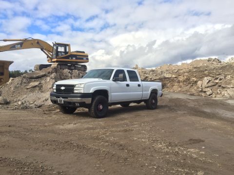 2006 Chevrolet Silverado 2500 - White 2006 Chevrolet Silverado 2500 pickup truck at a construction site with an excavator.