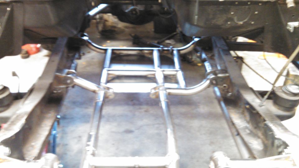Close-up of a truck's frame and suspension system, showing metal tubing and structural components