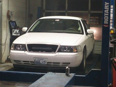 2000 Mercury Grand Marquis - White sedan on a car lift, front view, with a Nevada license plate.