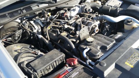 1991 Ford LTD Crown Victoria - Close-up view of a car's engine bay, showing complex mechanical systems and wiring.
