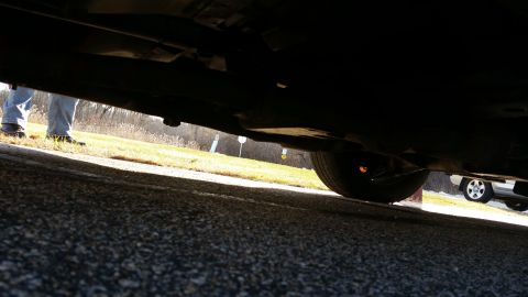1991 Ford LTD Crown Victoria - A low-angle view of a car's undercarriage, with another vehicle in the distance.