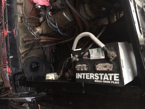 1978 Ford Bronco - Close-up view of an engine bay an Interstate Mega-Tron Plus battery and associated wiring.