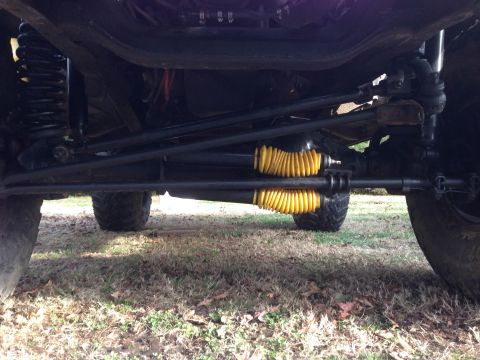 1979 Ford Bronco - Close-up of the steering and suspension system, showing yellow bellows on tie rods.