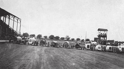 1909 Ford Model T - A line of early 20th-century automobiles are visible, suggesting a gathering or event from that era.