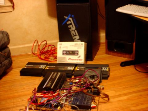 1973 Ford Ranchero - Multiple car audio amplifiers and a Pioneer stereo head unit are laid out on a wooden floor.