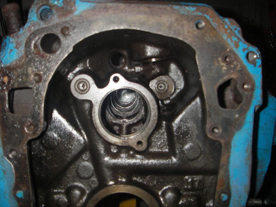 Engine block interior with oil residue and a metal plate with screws