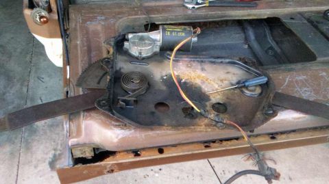 1982 Ford Bronco - Close-up of a disassembled car door window regulator mechanism, showing rust and exposed wires.
