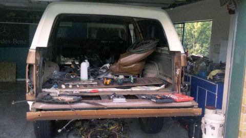 1982 Ford Bronco - This 1982 Ford Bronco's interior and cargo area are filled with parts and tools, suggesting a rebuild or restoration project is underway.