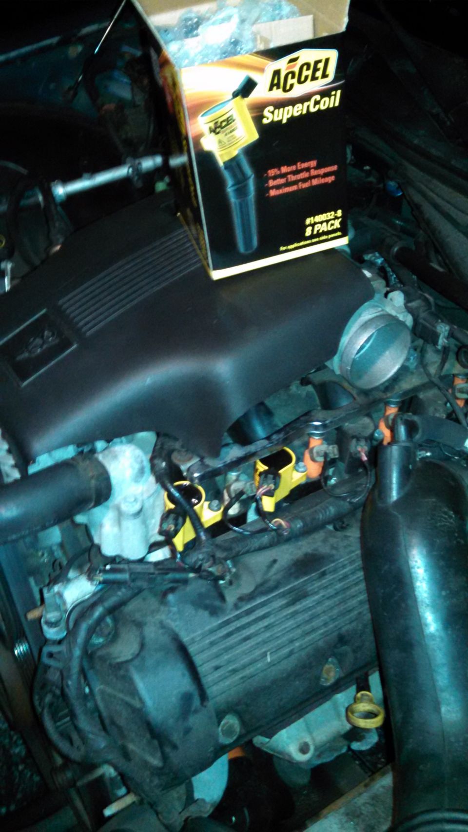 Engine bay with ACCEL SuperCoil 8-pack box and yellow ignition coils installed on a V8 engine