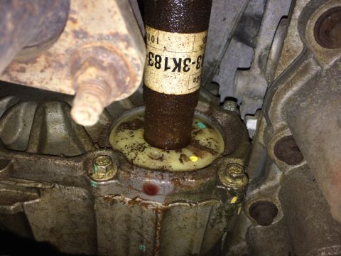 2011 Ford Elite - This image shows a close-up view of a driveshaft seal and its surrounding housing, with visible part numbers on the driveshaft.