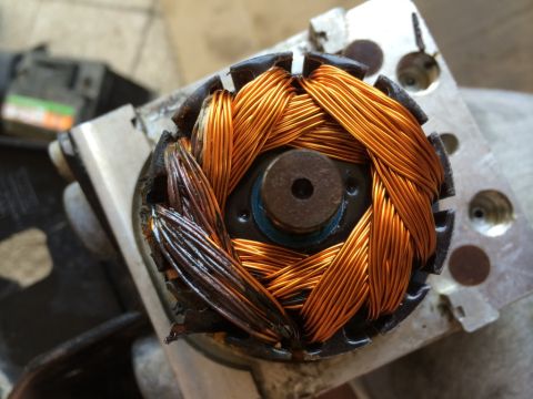 2011 Ford Elite - Close-up of an electric motor rotor with copper windings, some showing signs of heat damage.