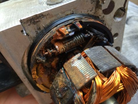 2011 Ford Elite - The internal components of an electric motor show significant wear and corrosion, with damaged brushes and a rusted armature.