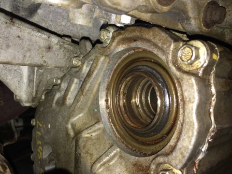 2011 Ford Elite - A close-up view of a vehicle's transmission housing and seal, showing signs of wear and grease.