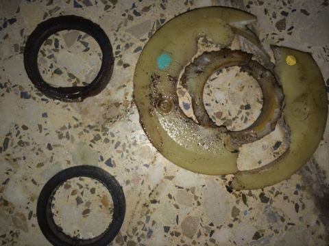 2011 Ford Elite - Worn-out vehicle parts, likely seals and a housing, are laid out on a tiled surface.