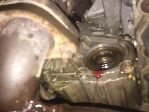 2011 Ford Elite - A close-up view of a vehicle's drivetrain component shows a leaking seal with fluid dripping down the bottom.