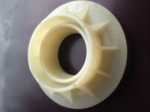 2011 Ford Elite - A close-up view of a plastic component, possibly a bearing or spacer, with visible text indicating 'PAG6'.