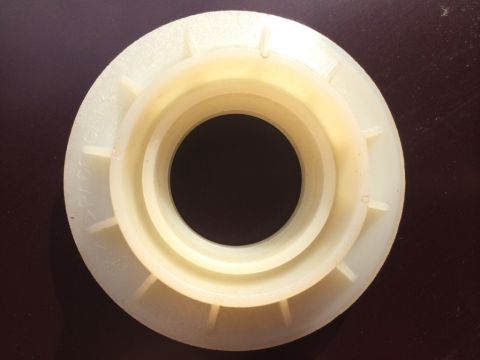 2011 Ford Elite - Close-up of a cream-colored plastic part with concentric rings and radial fins, showing some visible text.