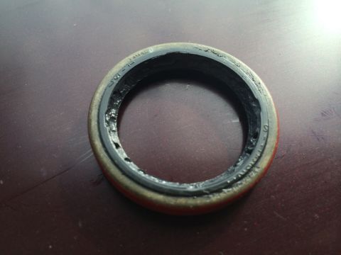 2011 Ford Elite - A damaged automotive seal is shown, with text visible on its outer edge.