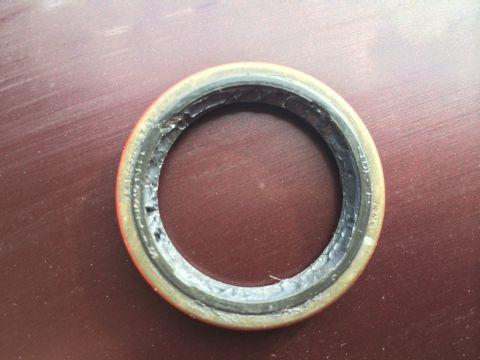 2011 Ford Elite - A damaged oil seal is shown against a dark, textured background.