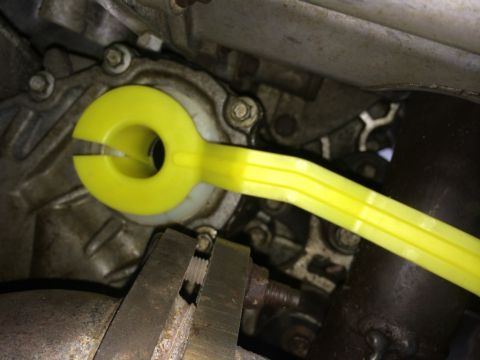 2011 Ford Elite - A yellow tool is positioned on the transmission housing of a vehicle.