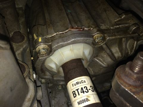 2011 Ford Elite - Close-up of a driveshaft seal with a FoMoCo label, indicating a vehicle part.