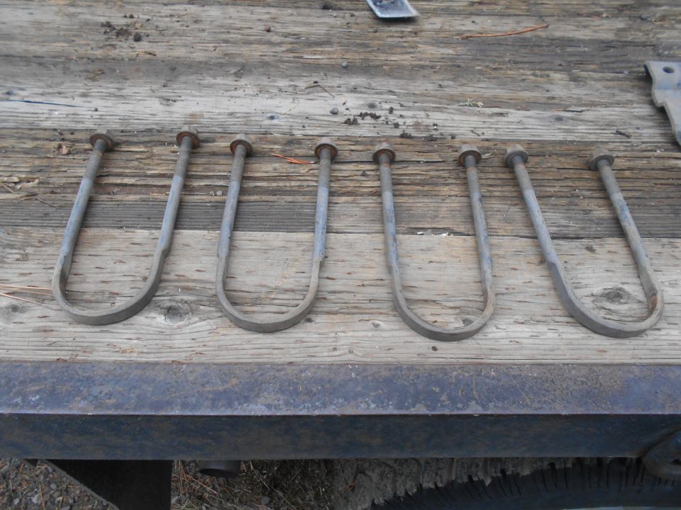six u-bolts on a wooden surface