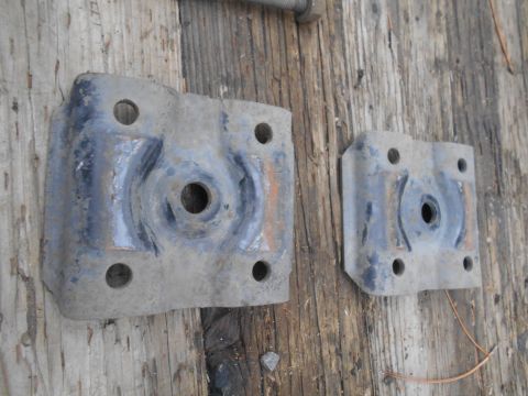1995 GMC Safari - Two metal brackets are shown on a wooden background. The registry claims they are from a 1995 GMC Safari.